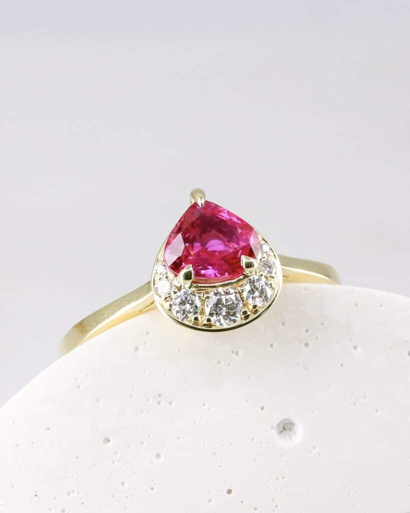 ‘Crescent’ engagement ring. Rubywith crescent moon halo of white diamonds, 18ct yellow gold